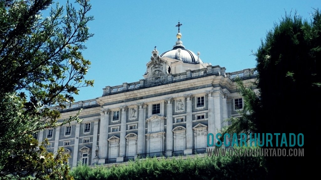 View of the Royal Palace of Madrid framed by trees from its garden