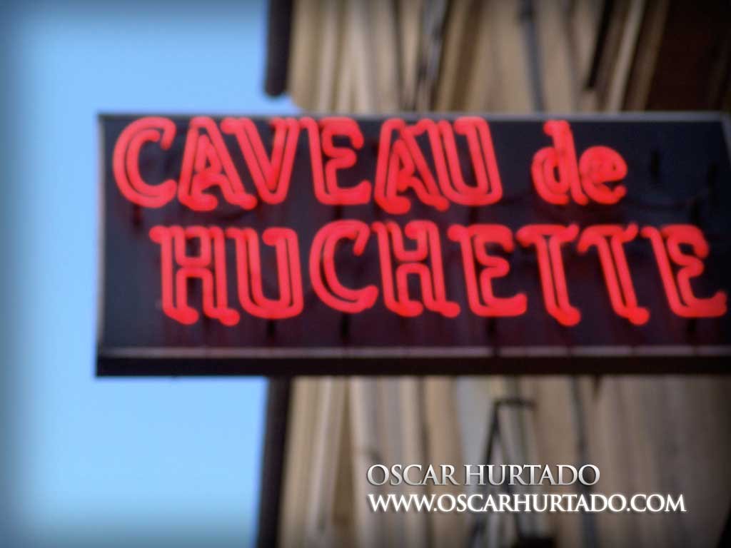 The iconic neon street sign for Le Caveau de la Huchette Jazz Club, notorious for its historical concerts by legends of this music genre