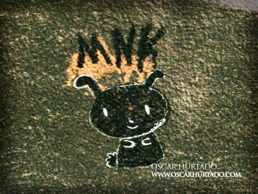 Black graffiti of a strange but cute creature over a dark textured wall