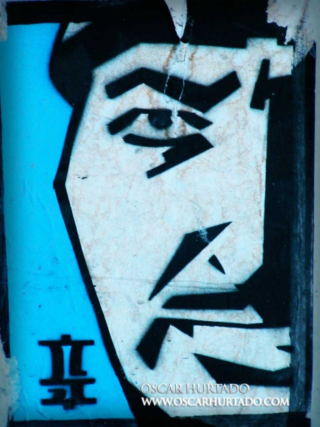 Iconic blue graffiti portraying the face of an Asian man