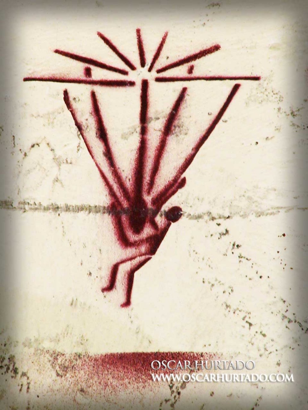 Red graffiti portraying a strange figure being abducted by aliens or attached to a kind of parachute
