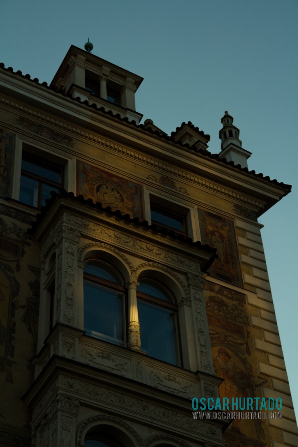 Beautiful golden hour sunrays hitting the window of an art nouveau building in Prague