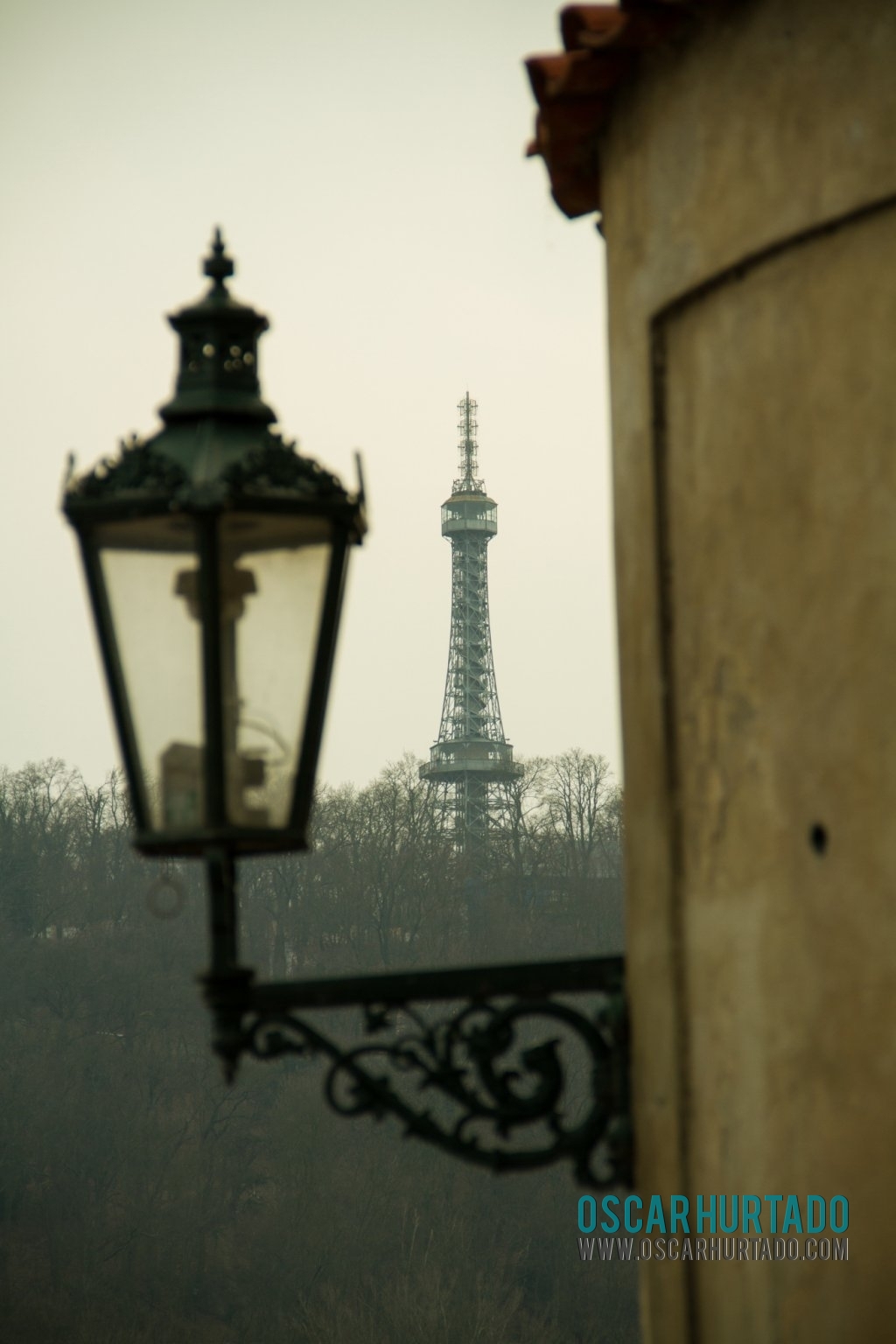 Distant view of the Petřín tower and framed by a street lamp