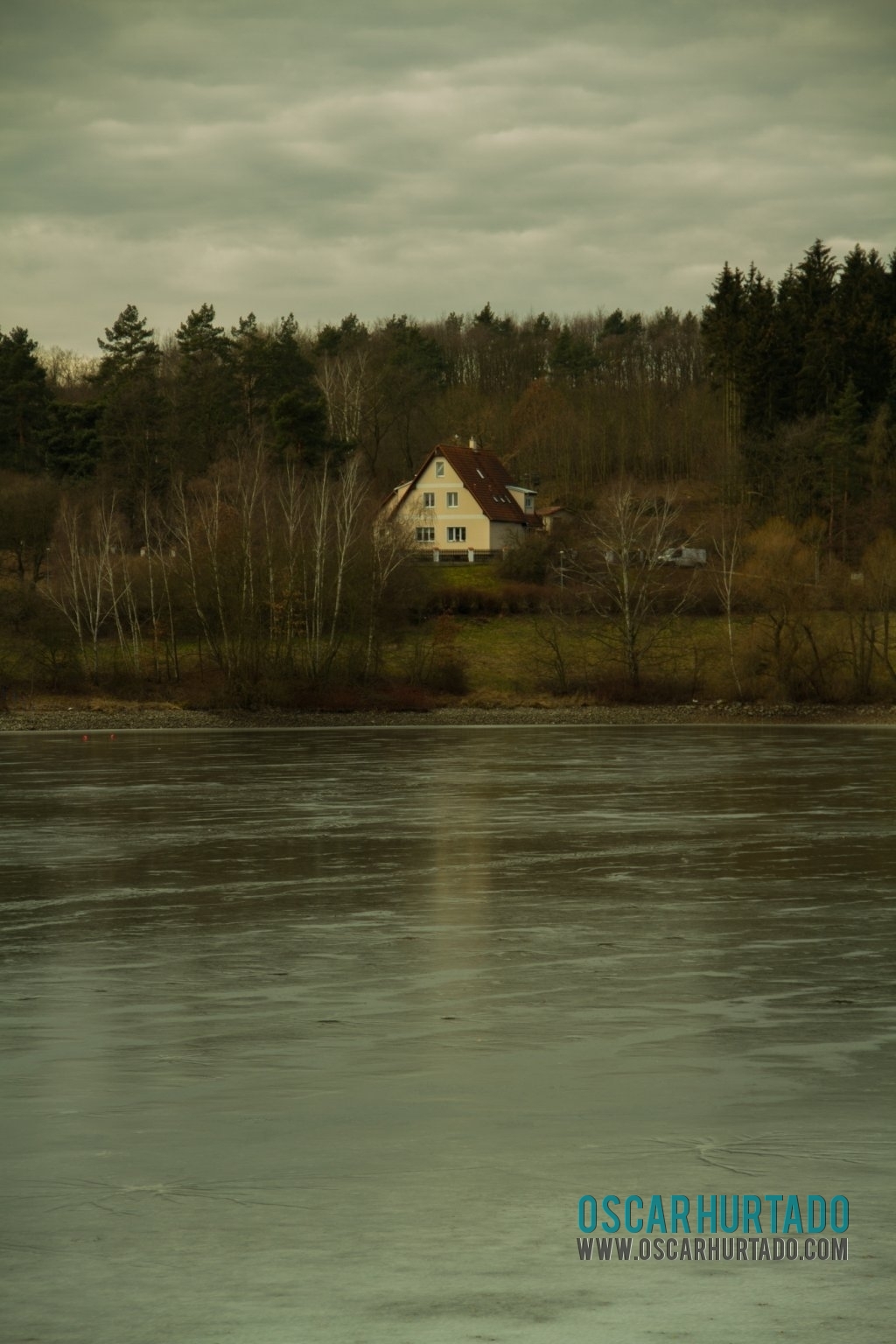 Beautiful distant view of a picturesque Czech home situated by a lake during winter season