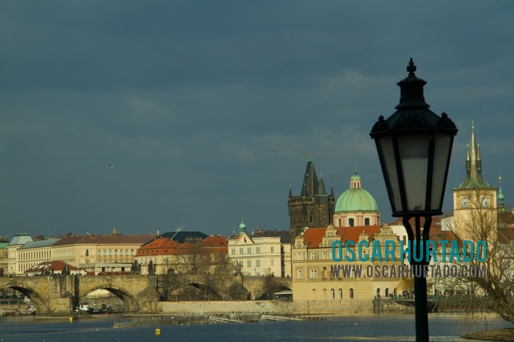 Panoramic view of the Prague city skyline with Charles Bridge and an art nouveau lamp on foreground
