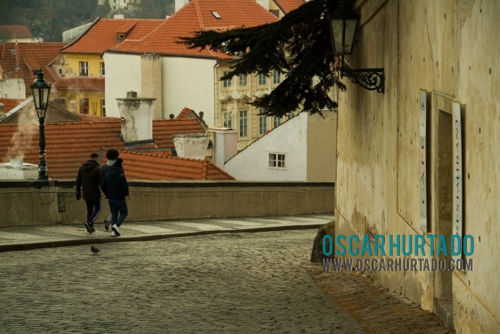 Some tourists make their way down from the Prague Castle through old street