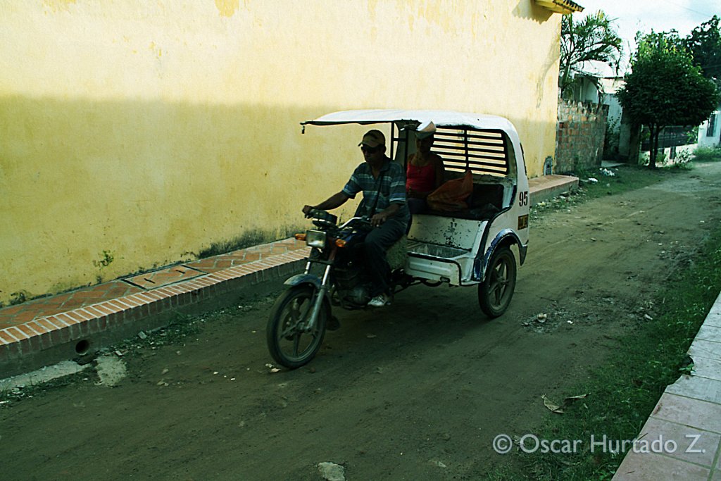 A woman goes for a ride on one of the typical three-wheel taxi bikes found in Mompox