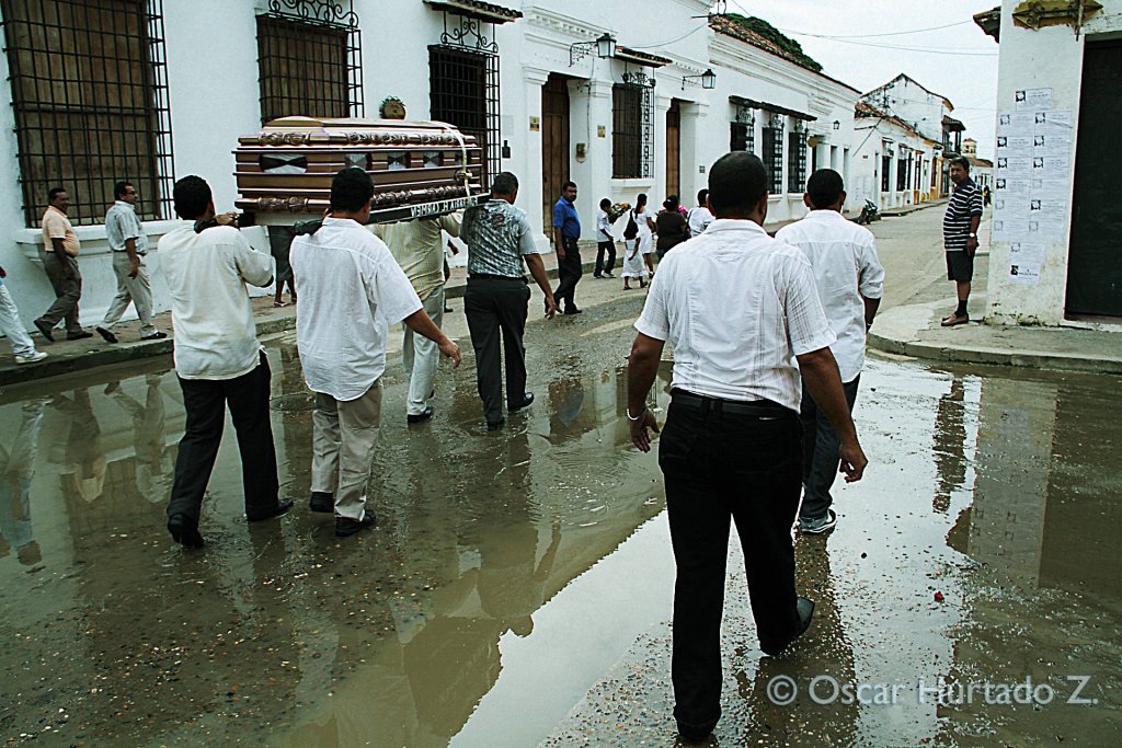 A group of men carry the coffin of a deceased local through the flooded streets of Mompox during one rainy afternoon