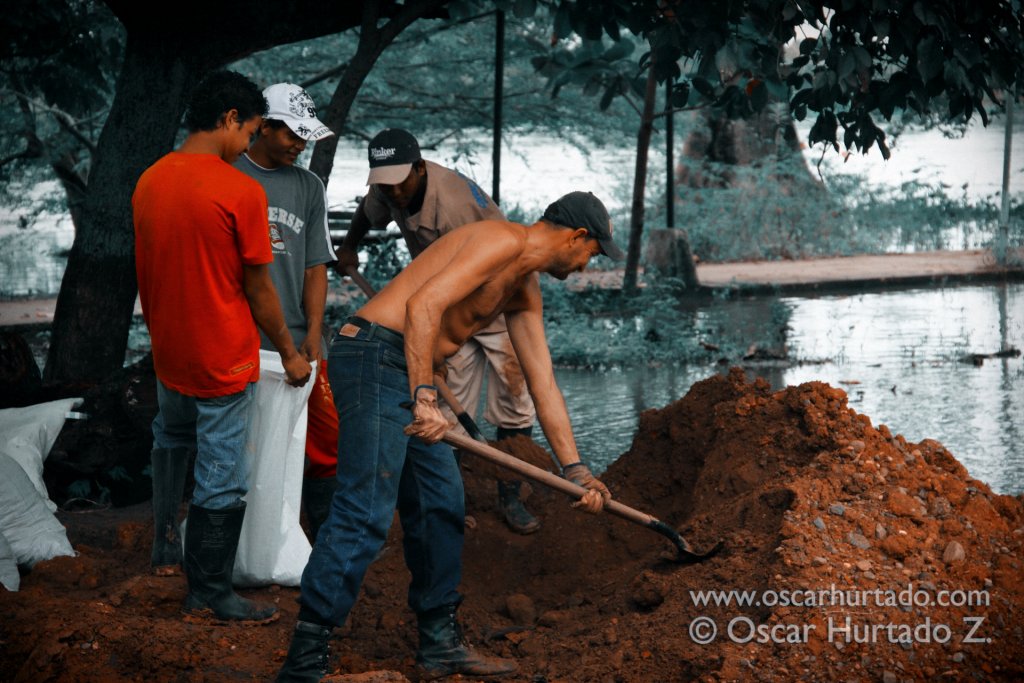 A group of local men work hard on filling up sandbags that will be used to prevent additional flooding of the streets in Mompox