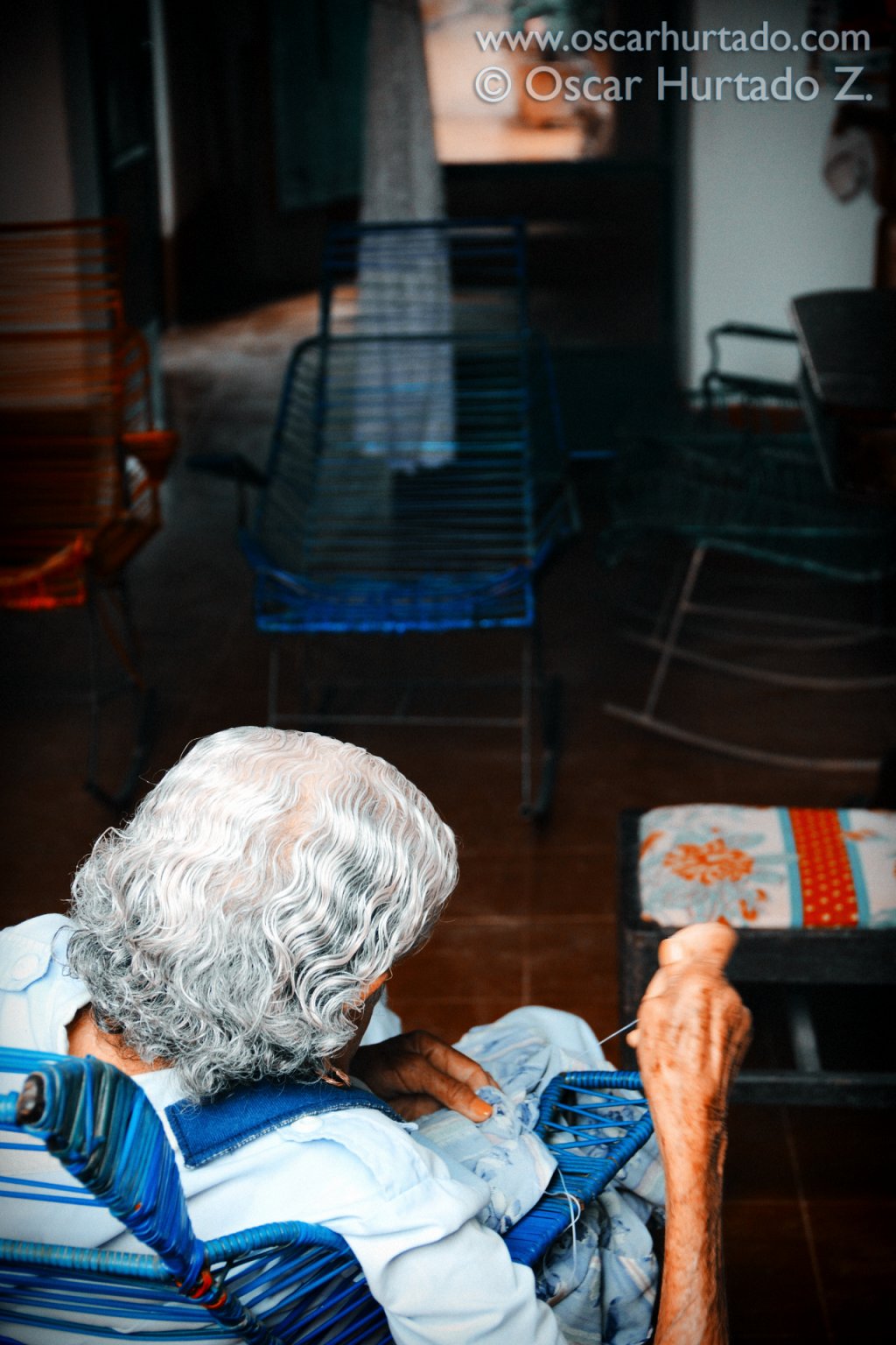 Picturesque view of an old lady peacefully sewing in her living room during one humid summer afternoon