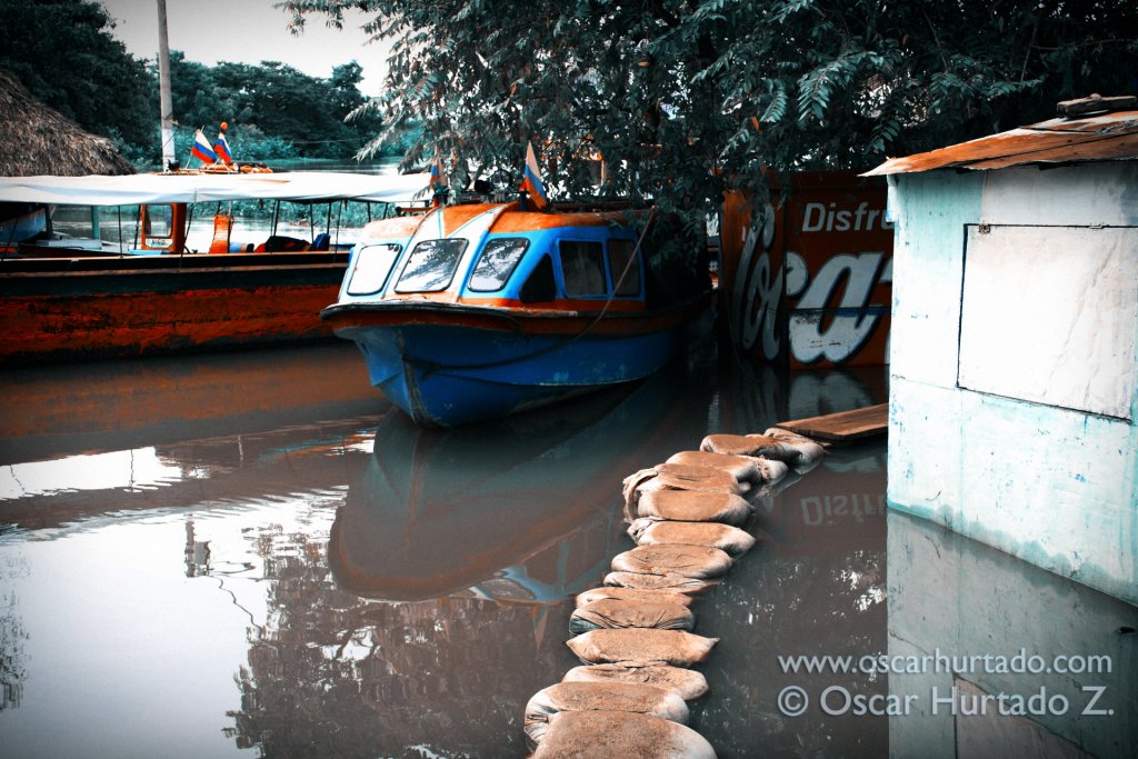 A series of sandbags serving as bridges to the boats across the flooded shores of the Magdalena river