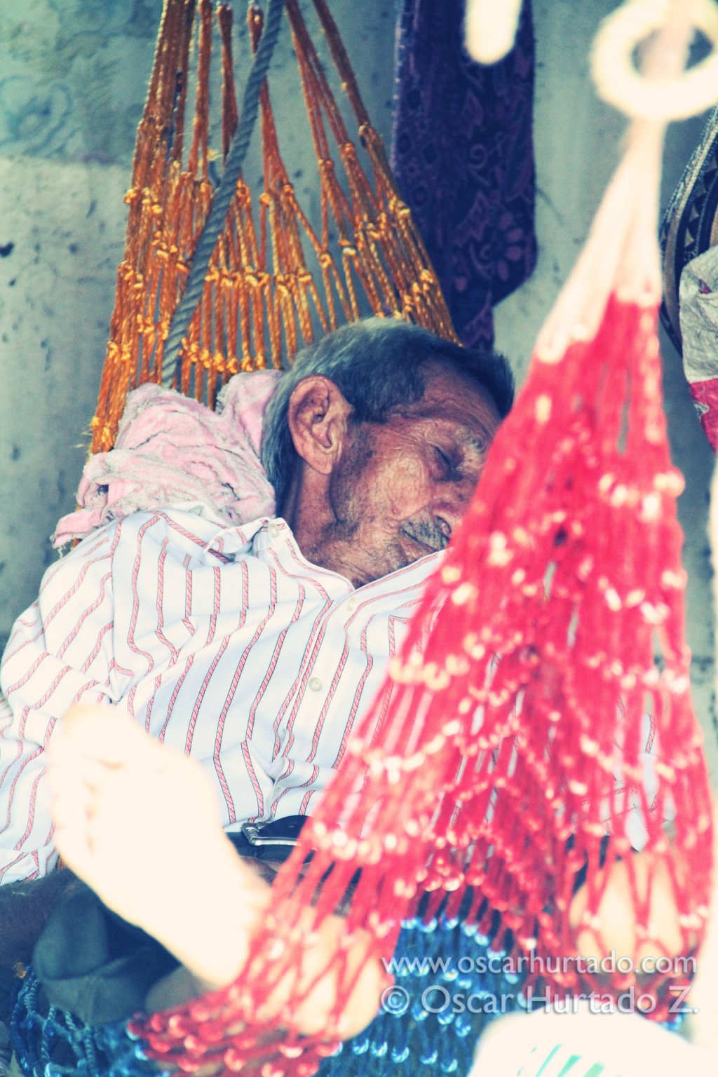 An old man taking a nap on his hammock during one humid summer afternoon by the Magdalena river